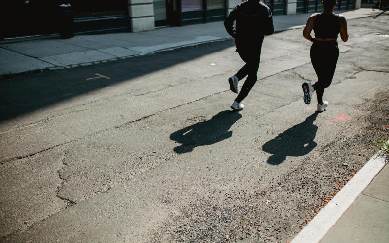 a couple people running on a street