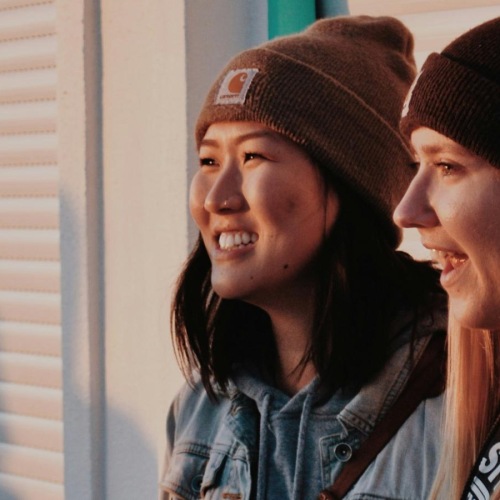 two woman standing next to each other and smiling
