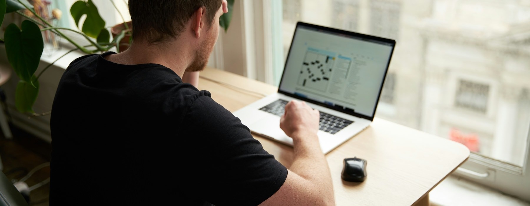 a man sitting at a table using a laptop