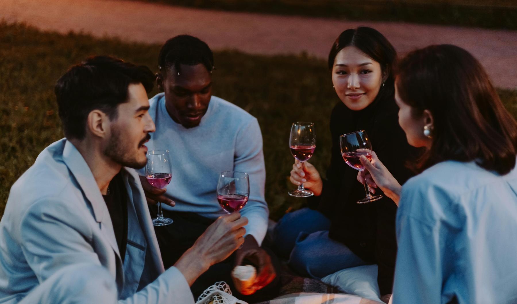a group of people sitting on a couch holding wine glasses